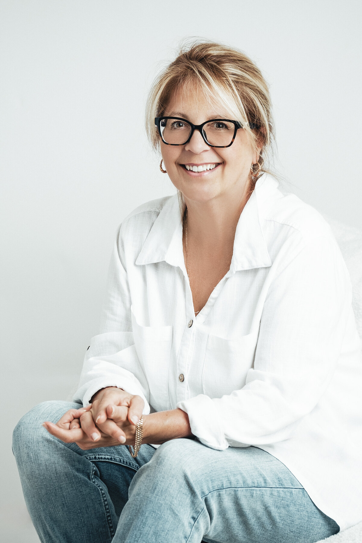 Chantal Létourneau, souriante, assise dans un fauteuil blanc